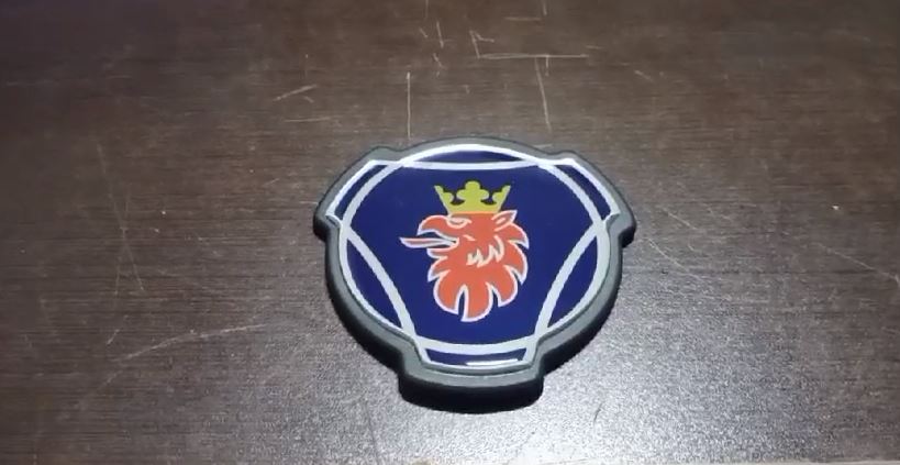 CP10354 - EMBLEMA SCANIA S5 S6 BRASAO RESINADO