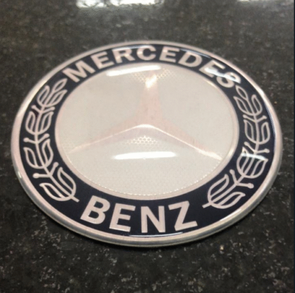 VL1289 - EMBLEMA CAPO CAFE MB ATEGO / AXOR / 1113 75MM ALUMINIO RESINADO
